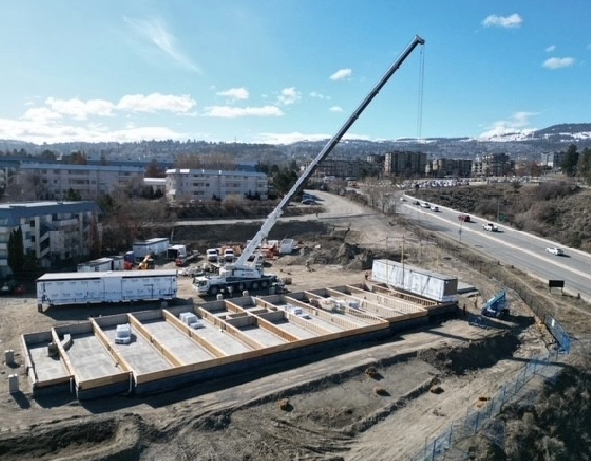 A crane placing a modular unit on a foundation